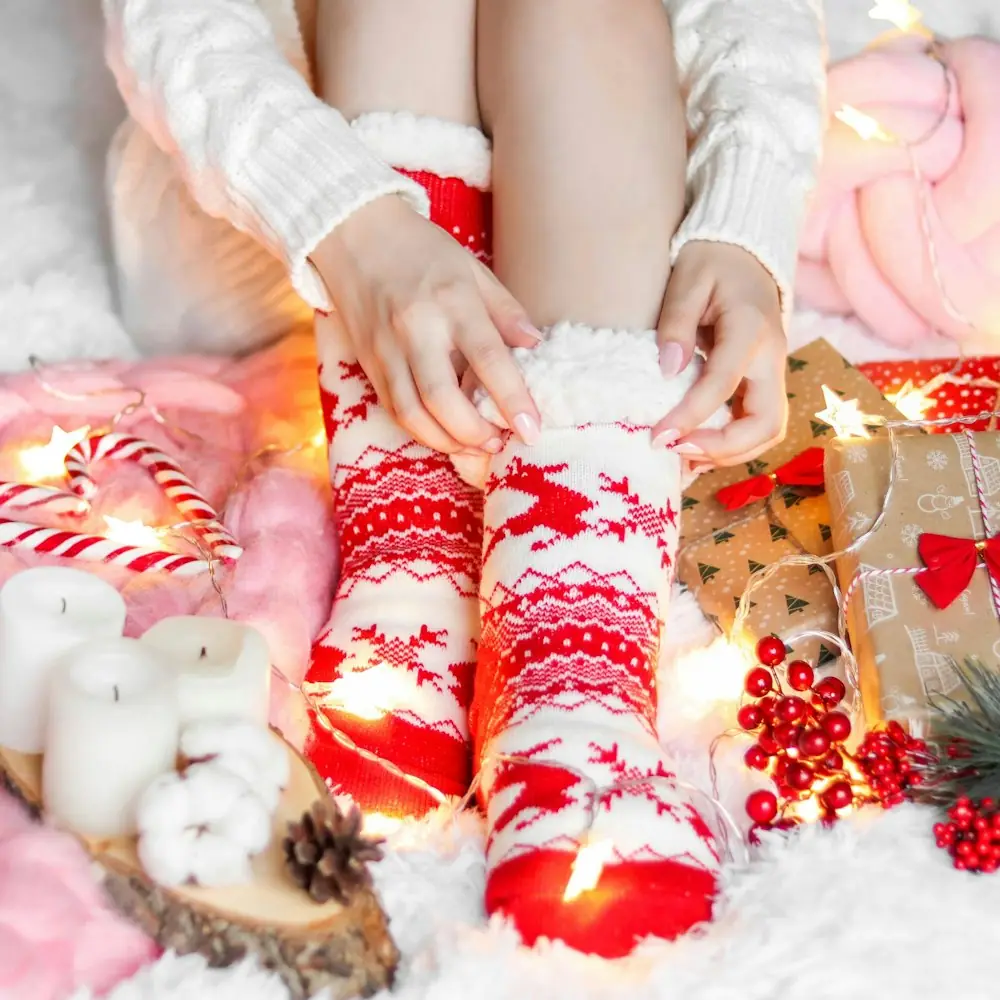 Cozy red and white Christmas socks surrounded by holiday decorations